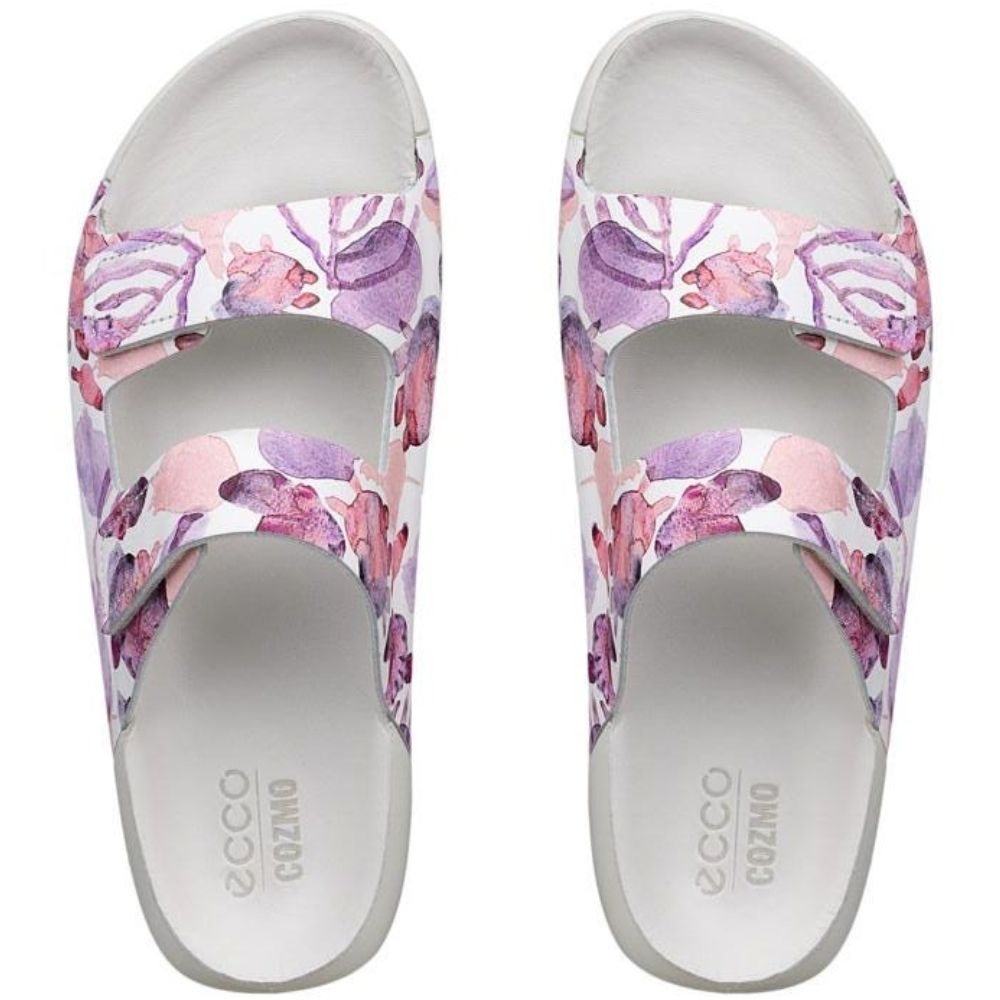 A pair of ECCO COZMO slide sandals featuring a watercolor floral pattern in shades of purple, pink, and white on the straps, with a white footbed.