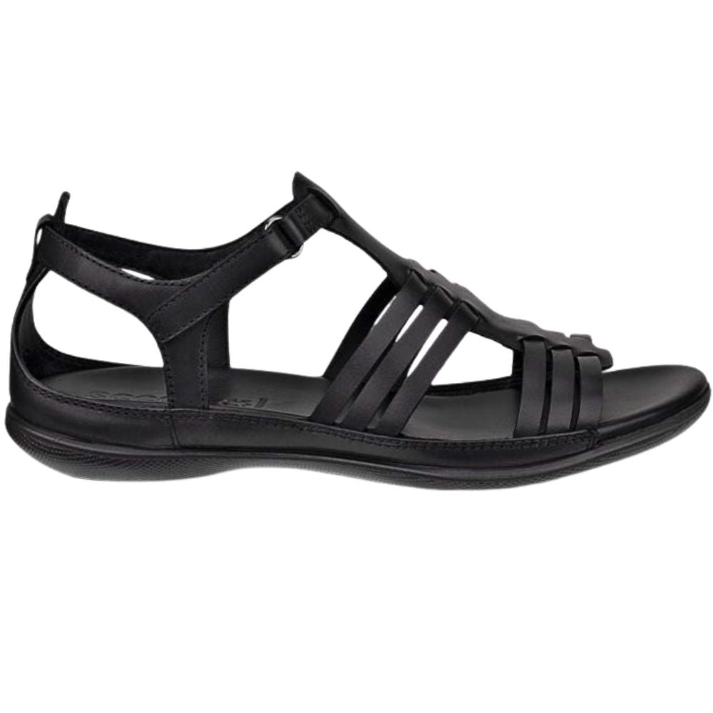 A black leather T-strap sandal with a low wedge heel, shown in a side profile view against a plain white background.