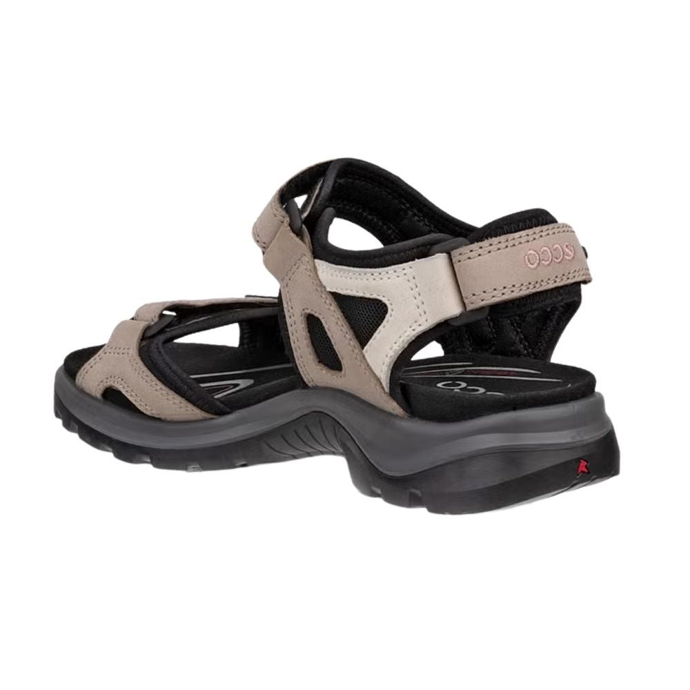 A single women's offroad sandal shown from a side profile view on a plain white background. The sandal features a beige and black upper with a thick, dual-toned black and dark gray sole.