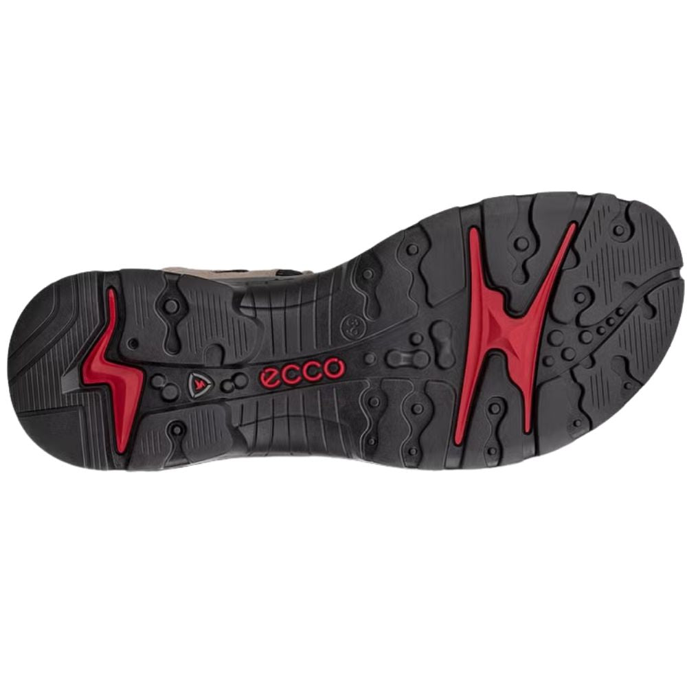 The black and red sole of an Ecco shoe, showing the brand name and tread pattern, isolated on a white background.