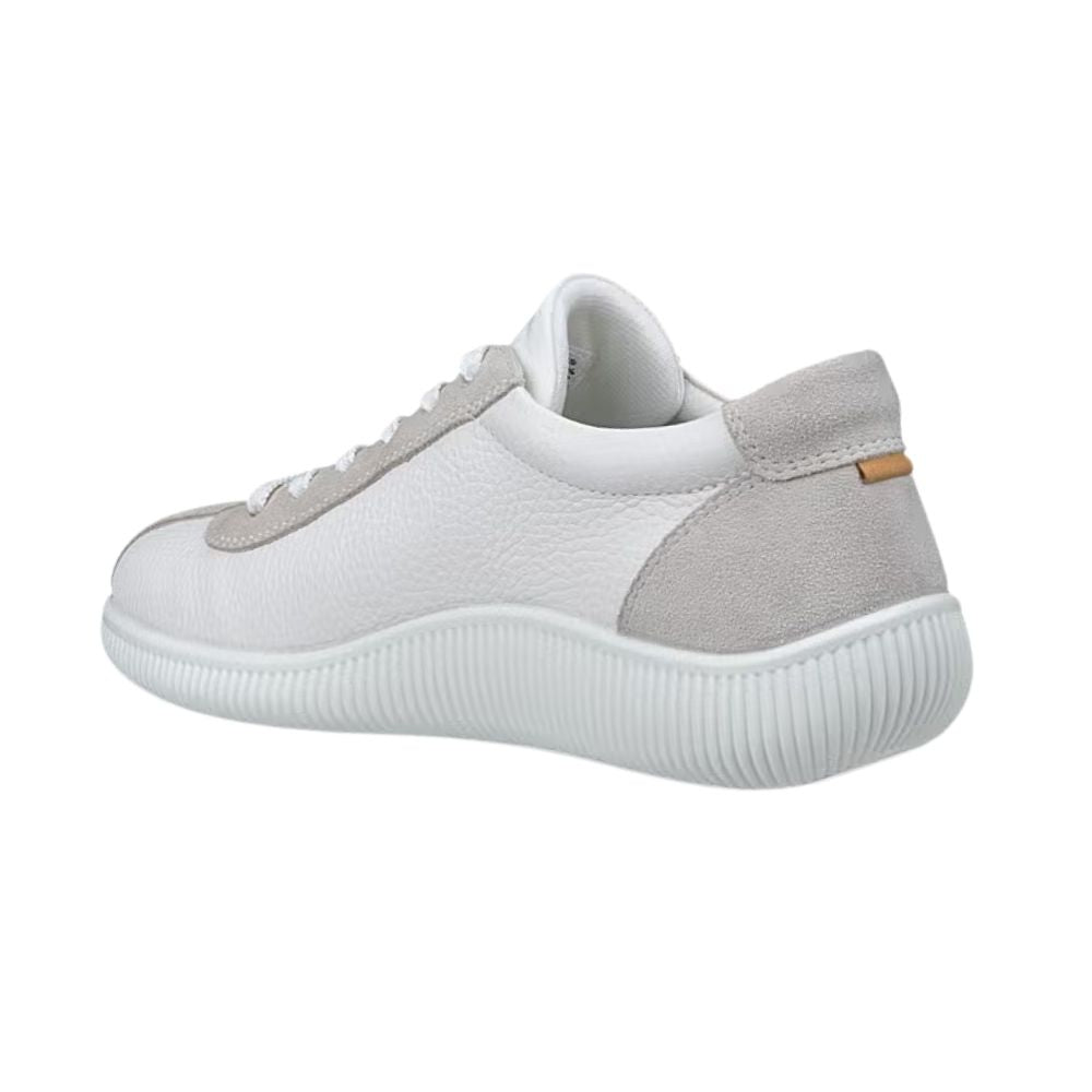 A low-top white leather sneaker with light gray suede overlays on the toe and heel, featuring a thick white ribbed sole and a small tan accent tab on the heel.