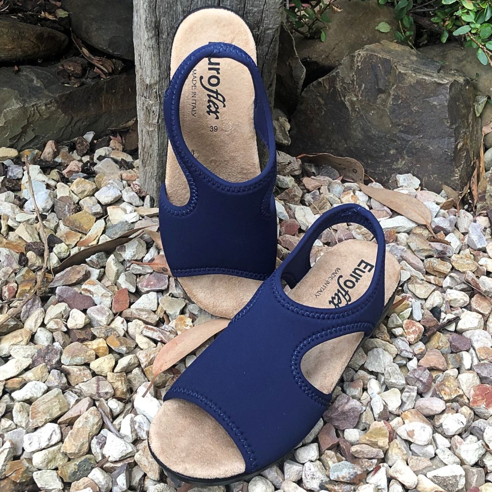 A pair of navy blue EUROFLEX SICILY sandals with a cushioned sole and lightweight design, placed on a rocky surface.