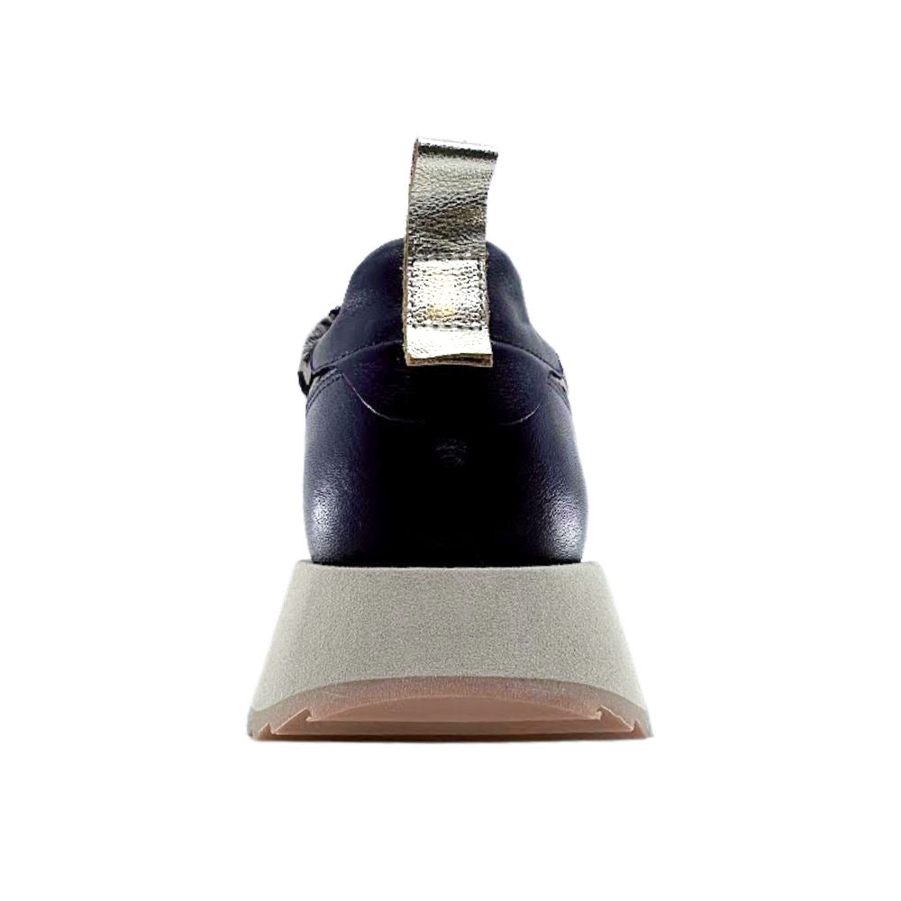 Back of black shoe with a gold pull tab on a white background