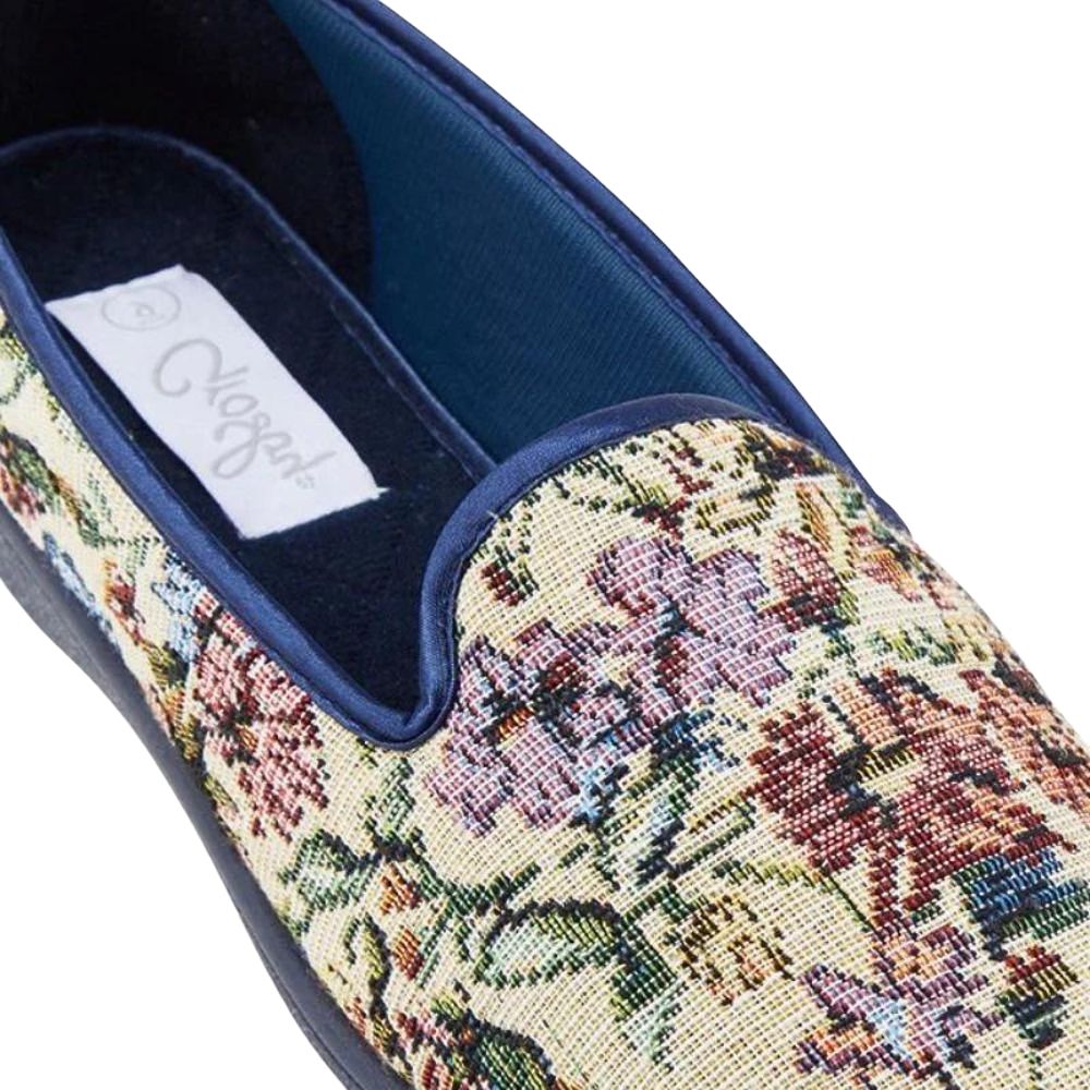 Floral patterned slipper with a brand label on a white background