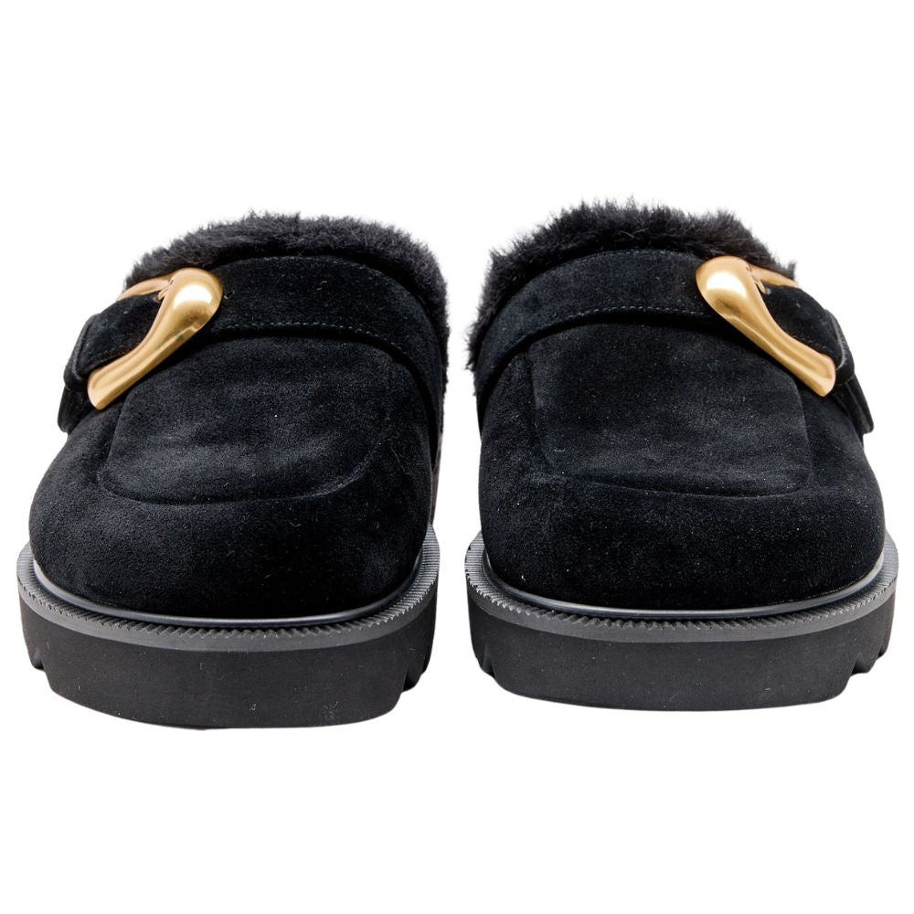 Black suede leather mule with fur lining and gold buckles on a white background