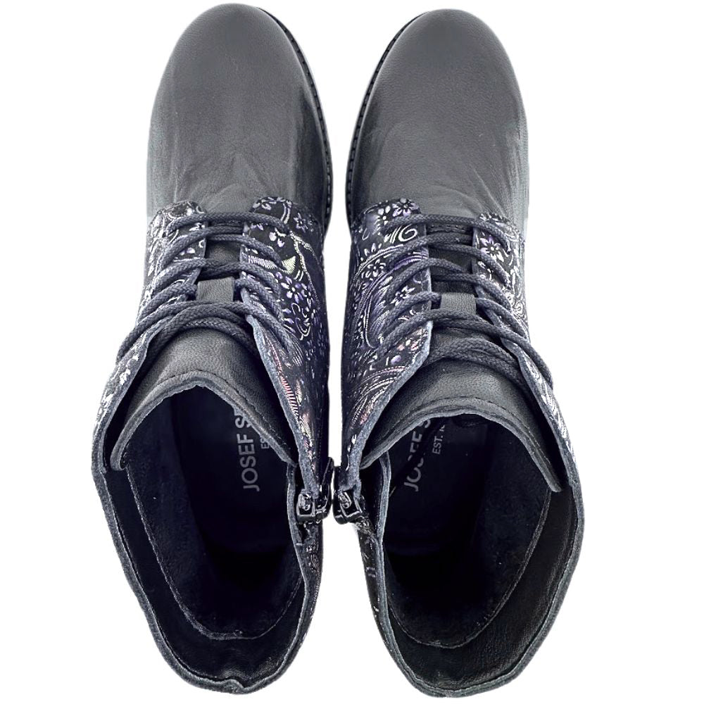 Pair of black boots with intricate patterned embellishments on a white background