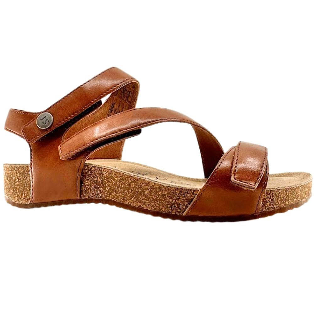 A single women's wedge sandal in brown leather with a textured cork-look wedge heel and a small metal button on the ankle strap, shown against a plain white background.