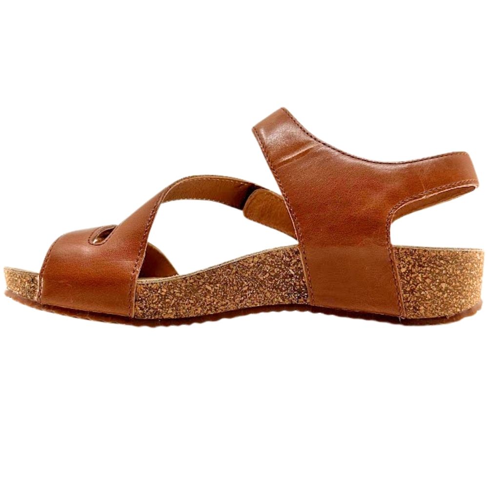 A single brown leather sandal with a chunky cork-textured wedge heel and a wide crossover front strap, shown in profile against a plain white background.