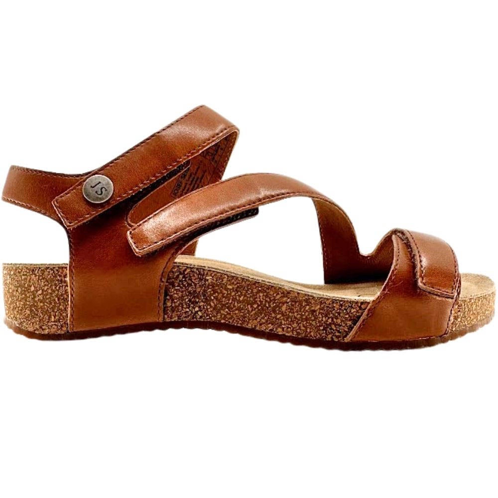 A single brown leather sandal with an ankle strap and a cork-textured wedge heel, shown from a side profile on a white background.
