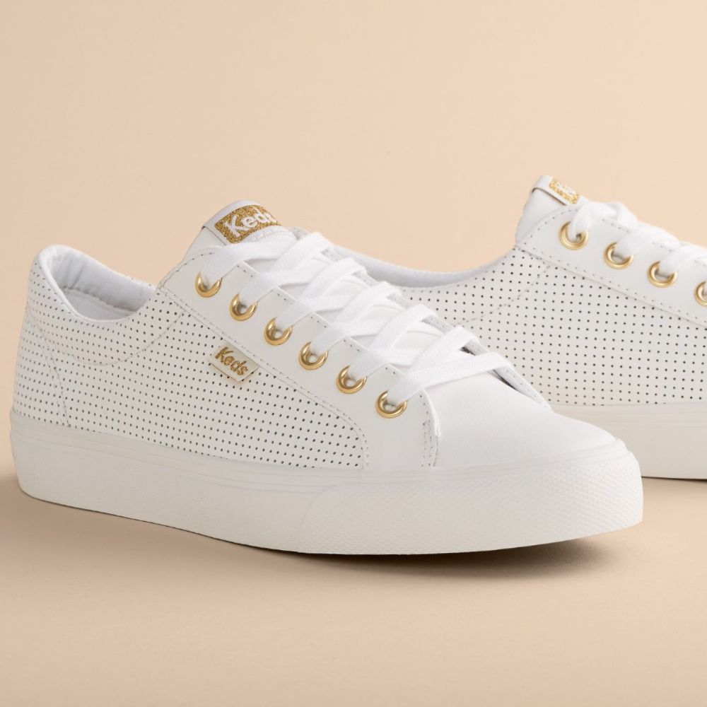 A pair of white perforated leather KEDS JUMP KICK sneakers with gold embellishments and a lace-up design.