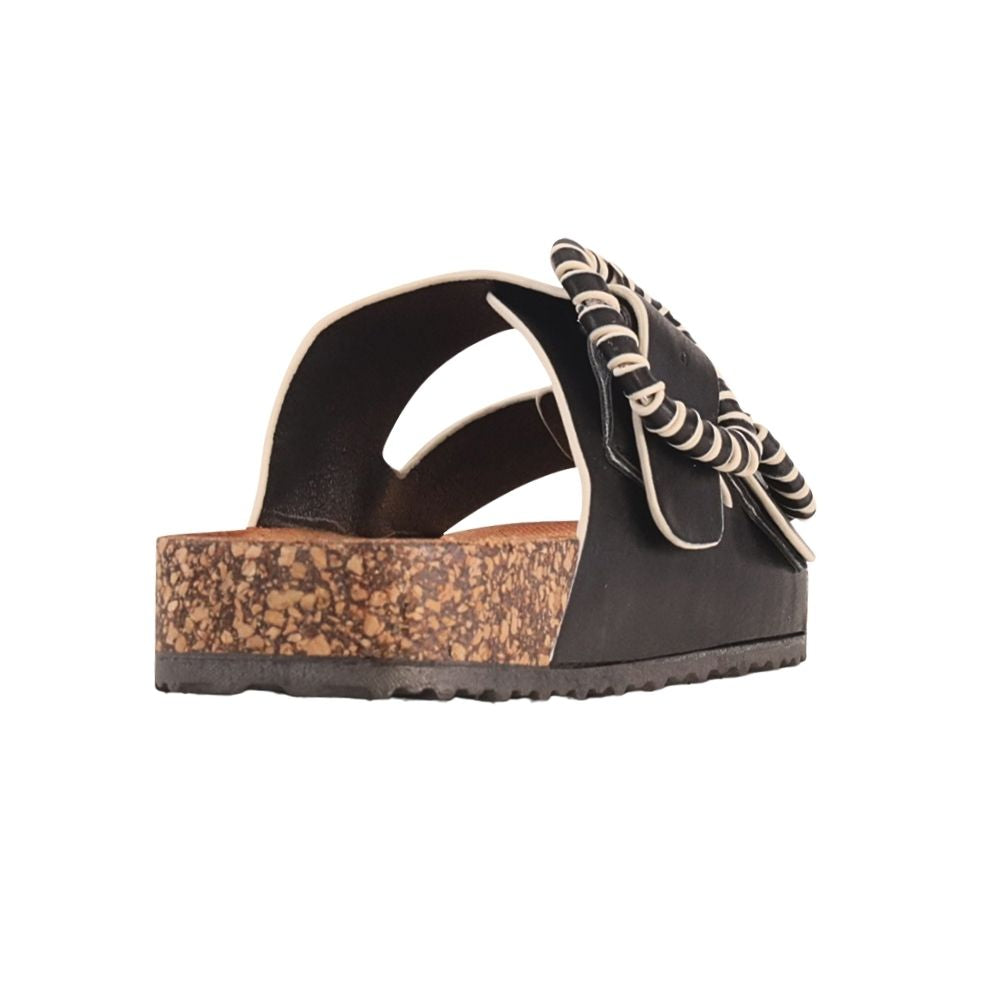 A single women's platform slide sandal shown from a side profile view against a solid white background. The sandal features a black Vegan leather upper with a cork-textured platform sole, and a decorative black and white striped braided trim on the buckles.