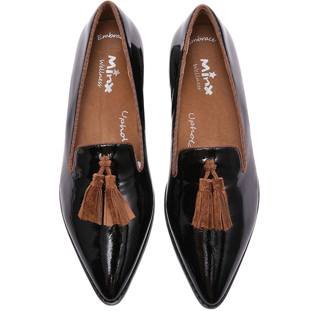 Black patent loafers with brown tassels on a white background