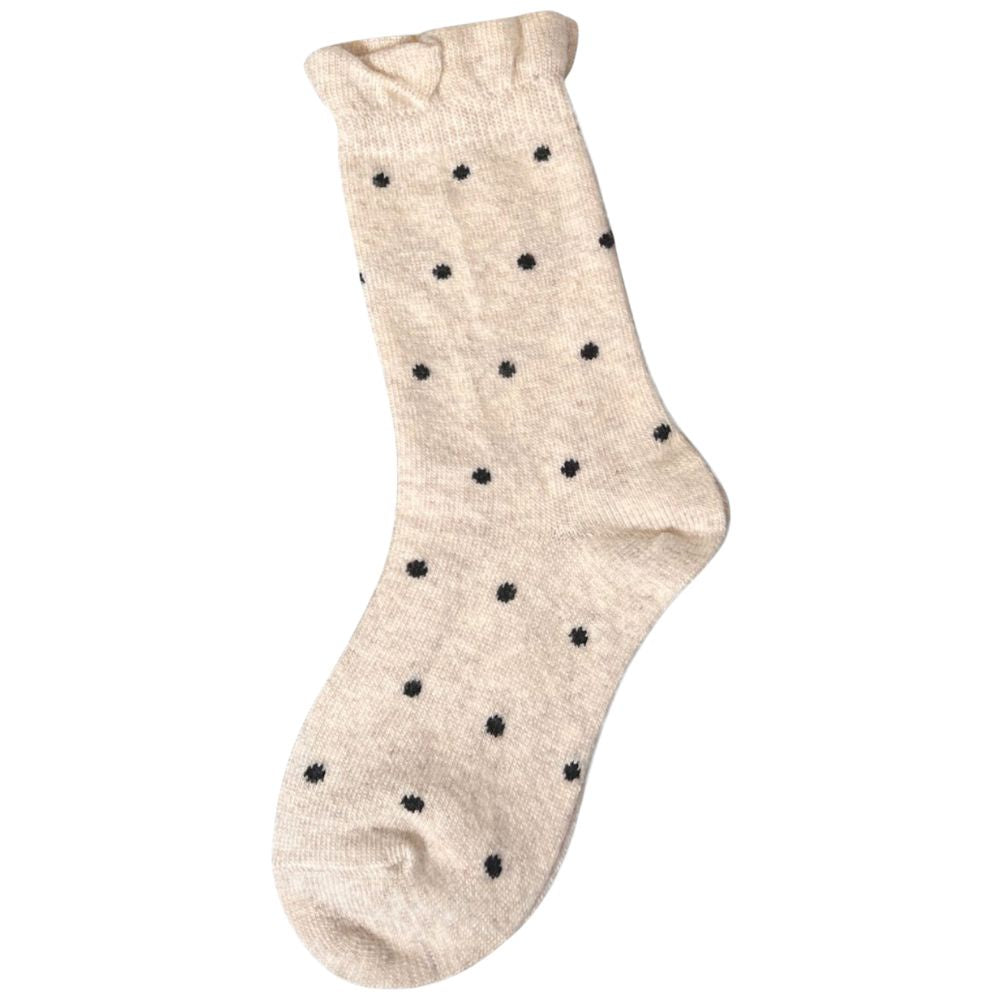 Beige sock with black dot pattern and frill cuff on a white background