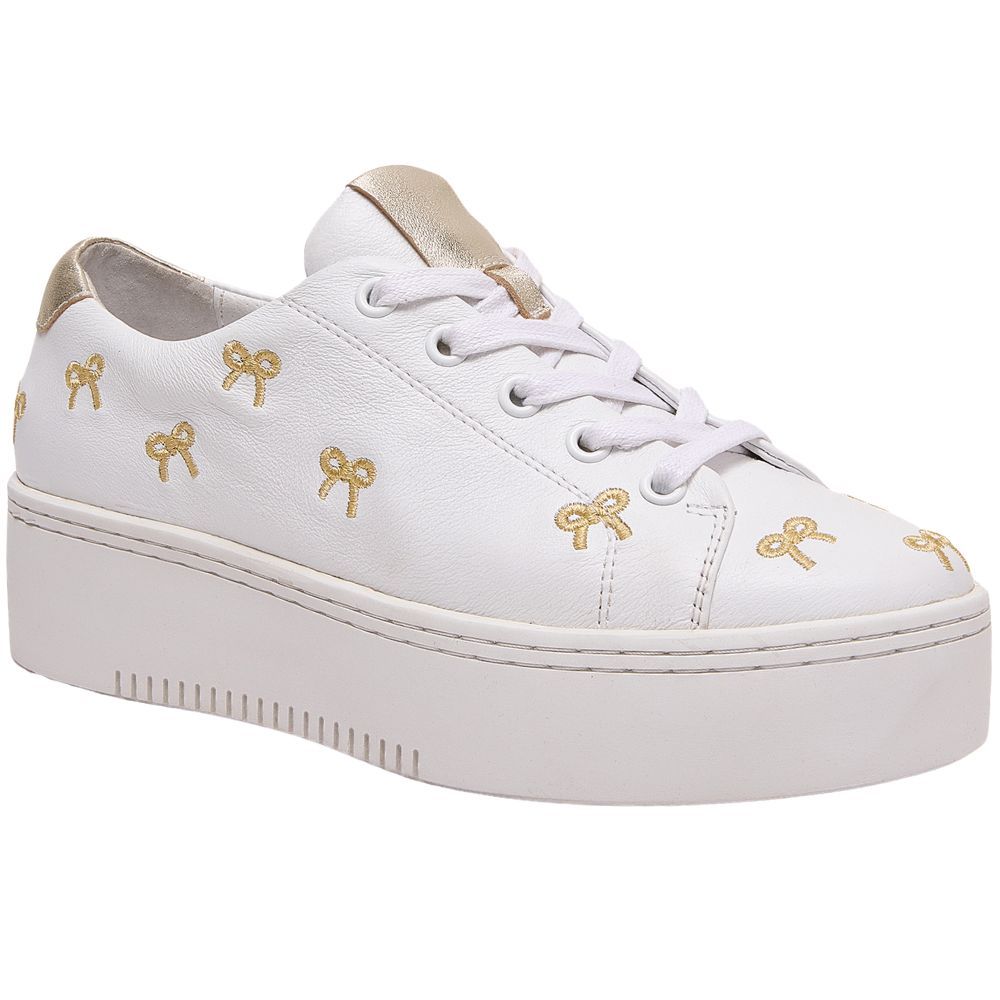 White sneaker with gold bow designs on a white background