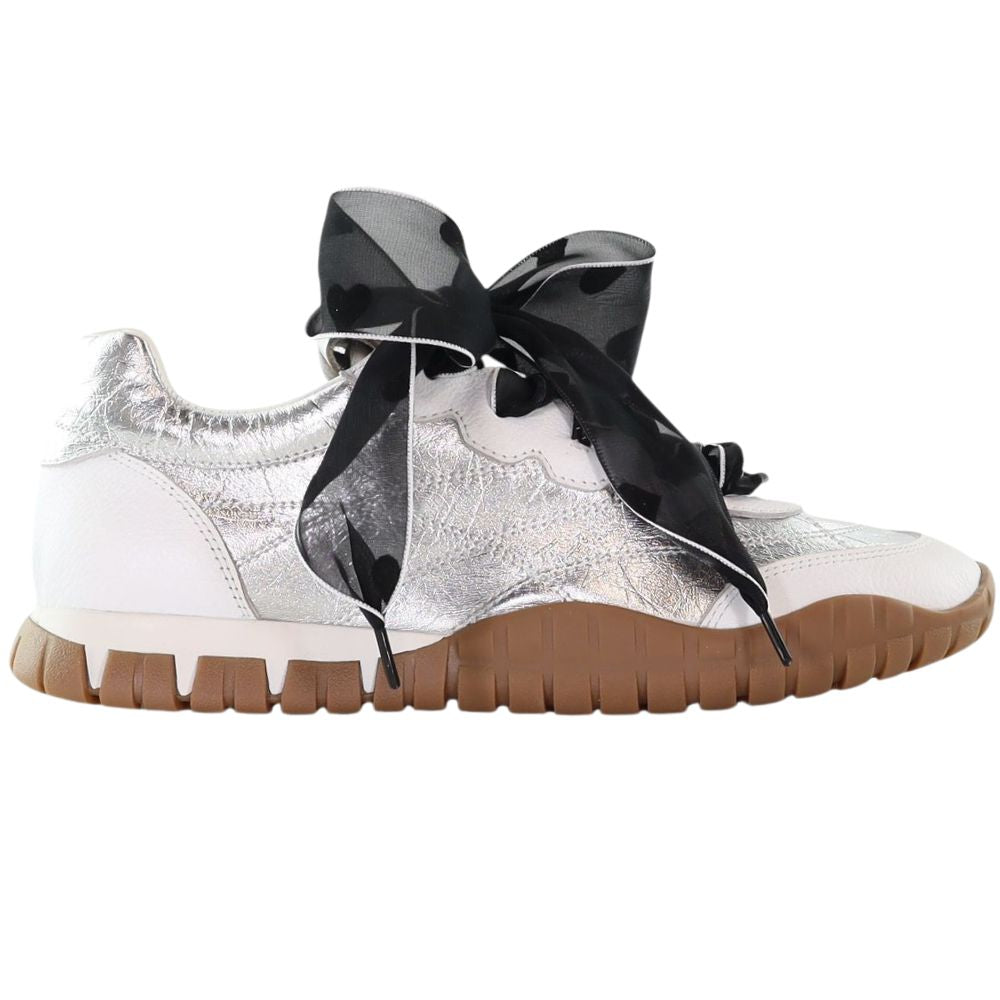 Silver sneakers with a black sheer bow lace with heart motifs on a white background