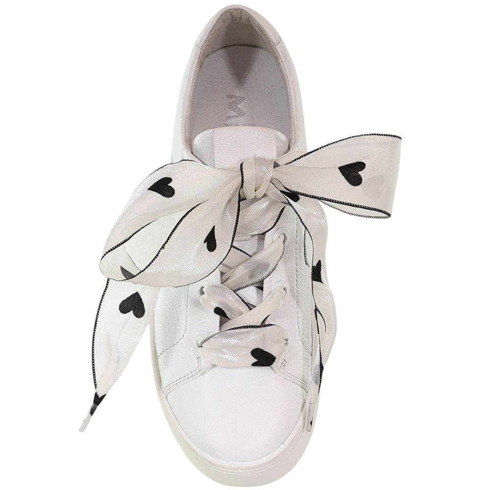White sneaker with sheer white lace with heart motifs on a white background