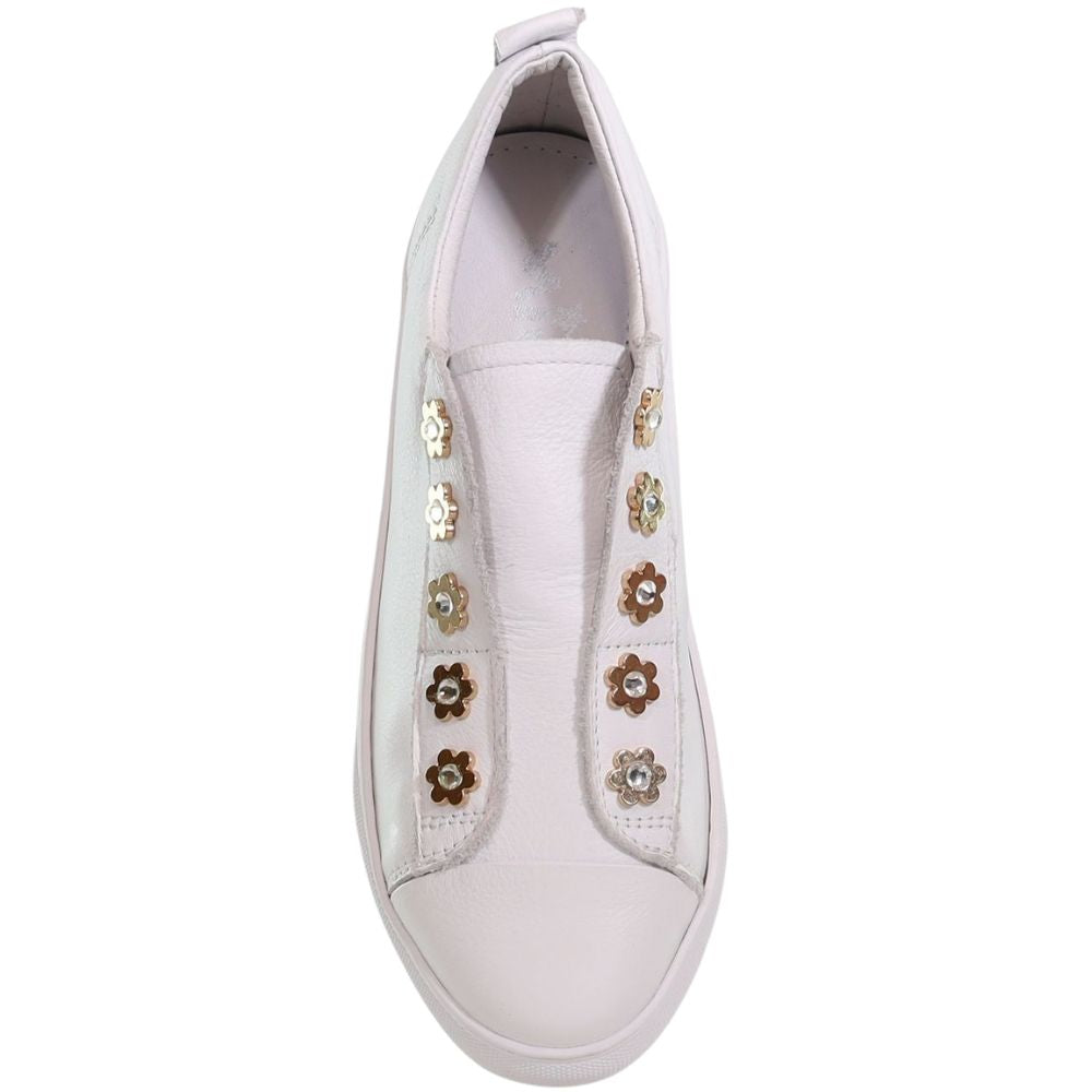A white slip-on sneaker featuring decorative gold flower embellishments  along the side, shown against a plain white background.