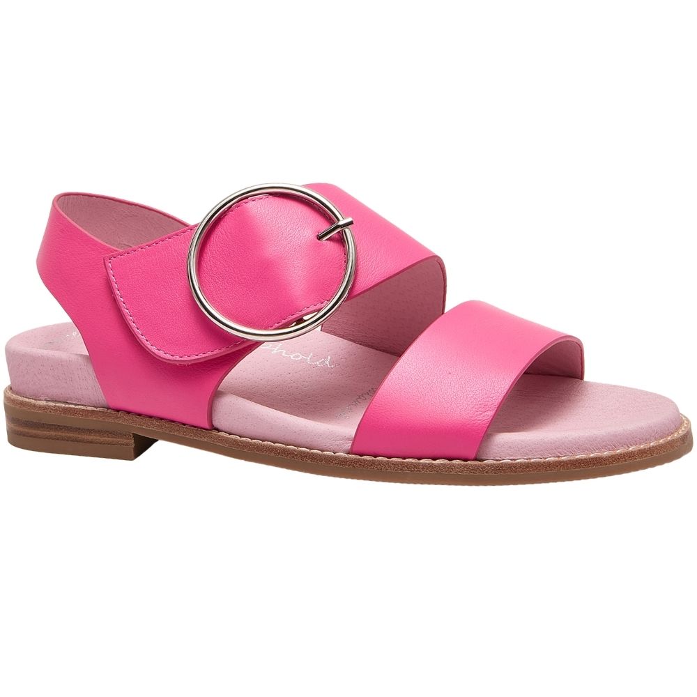 A bright pink leather slide sandal with a large silver-tone circular buckle detail across the top, a light pink footbed, and a brown stacked sole, shown against a plain white background.
