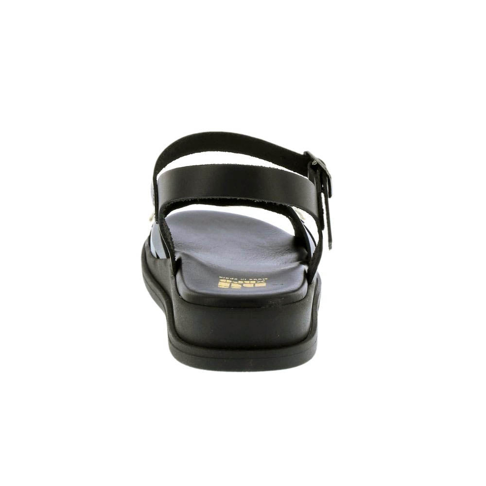 A black platform sandal with an adjustable ankle strap and a small gold logo on the insole, shown from a rear three-quarter view against a white background.