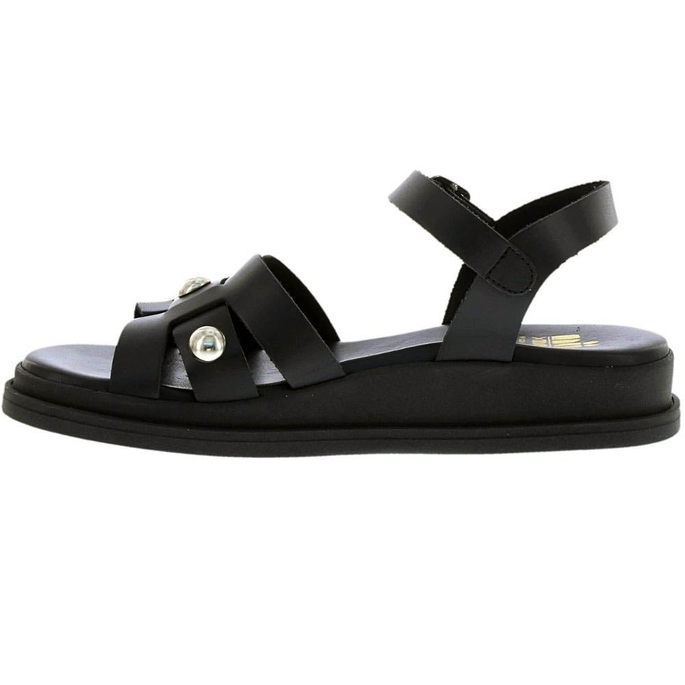 A black leather flat sandal with an ankle strap and two front straps adorned with round silver studs, shown in a side profile on a white background.
