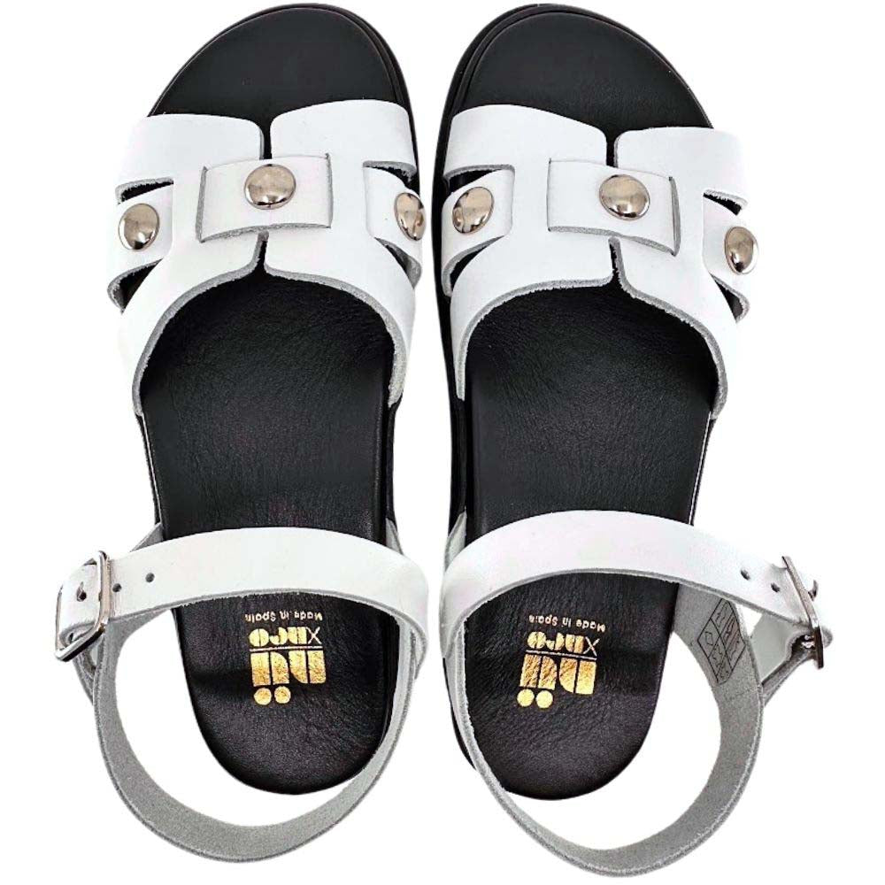 A pair of white leather slide sandals with black footbeds, silver stud details, and adjustable ankle straps, shown from a top-down view on a white background.