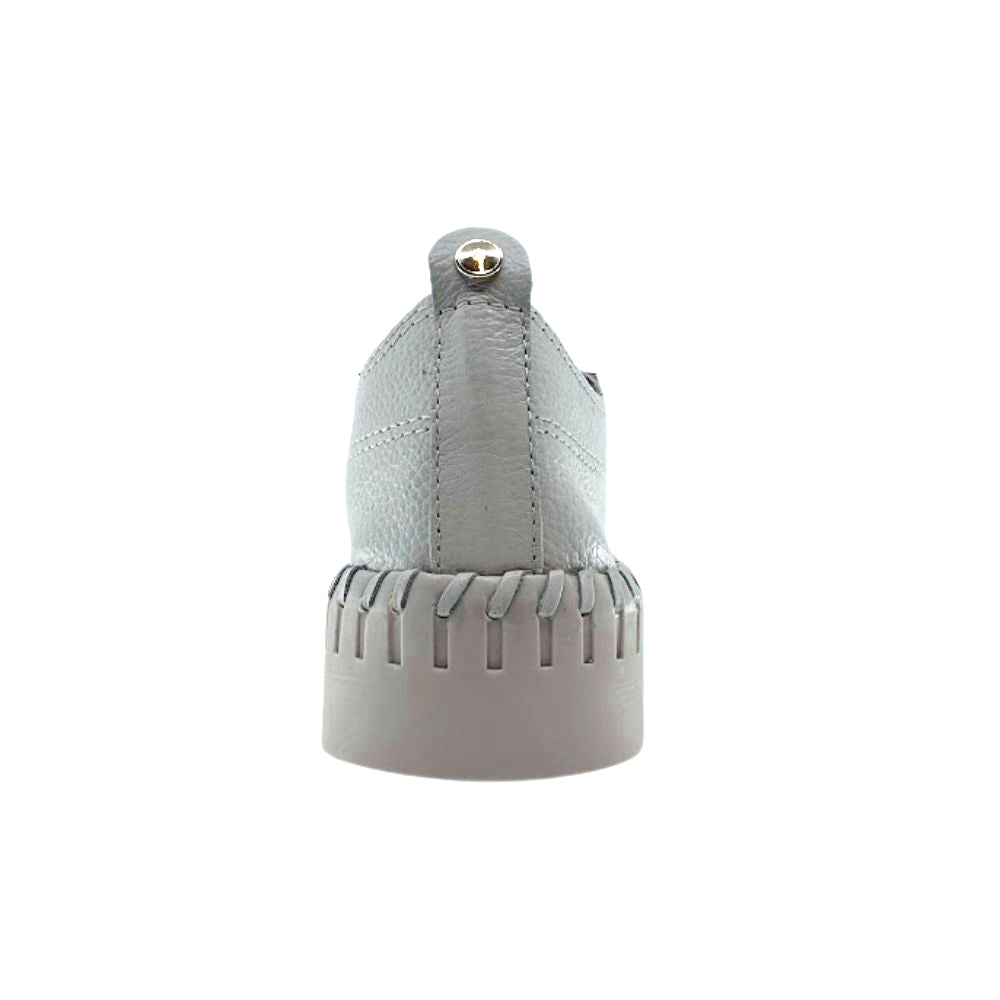Back of cream leather sneaker with a textured sole on a white background