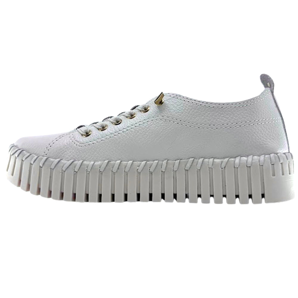 Inside of cream leather sneaker with cleated sole on a white background
