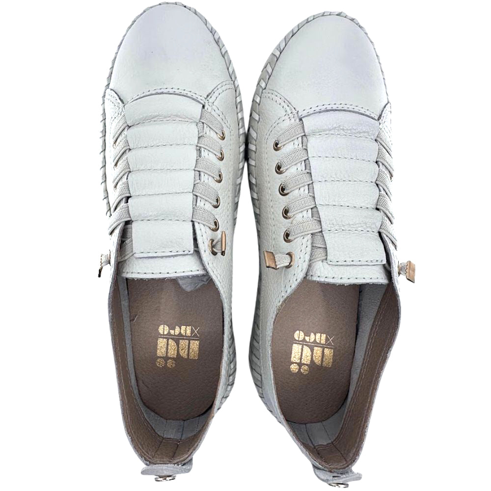 Pair of cream leather sneakers with gold accents on a white background