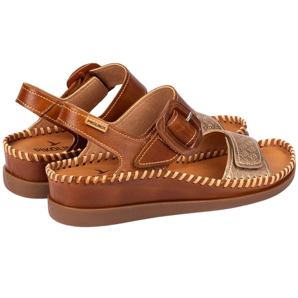 A pair of brown leather sandals with double straps, one featuring a buckle, shown on a plain white background.
