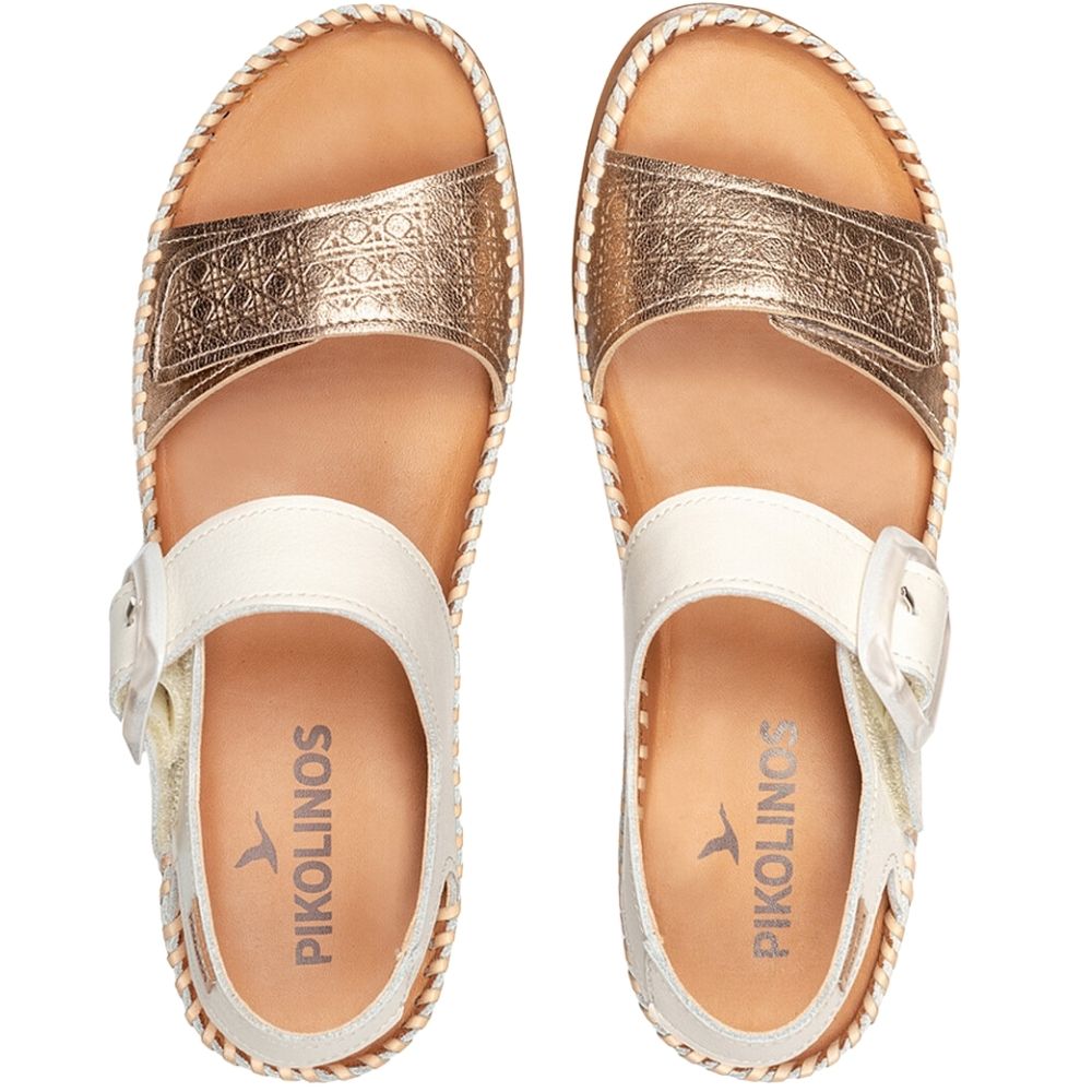 A pair of Pikolinos women's sandals shown from a top-down view. The sandals feature metallic gold straps with an embossed pattern, an off-white adjustable Velcro strap, and a braided rand sole on a white background.