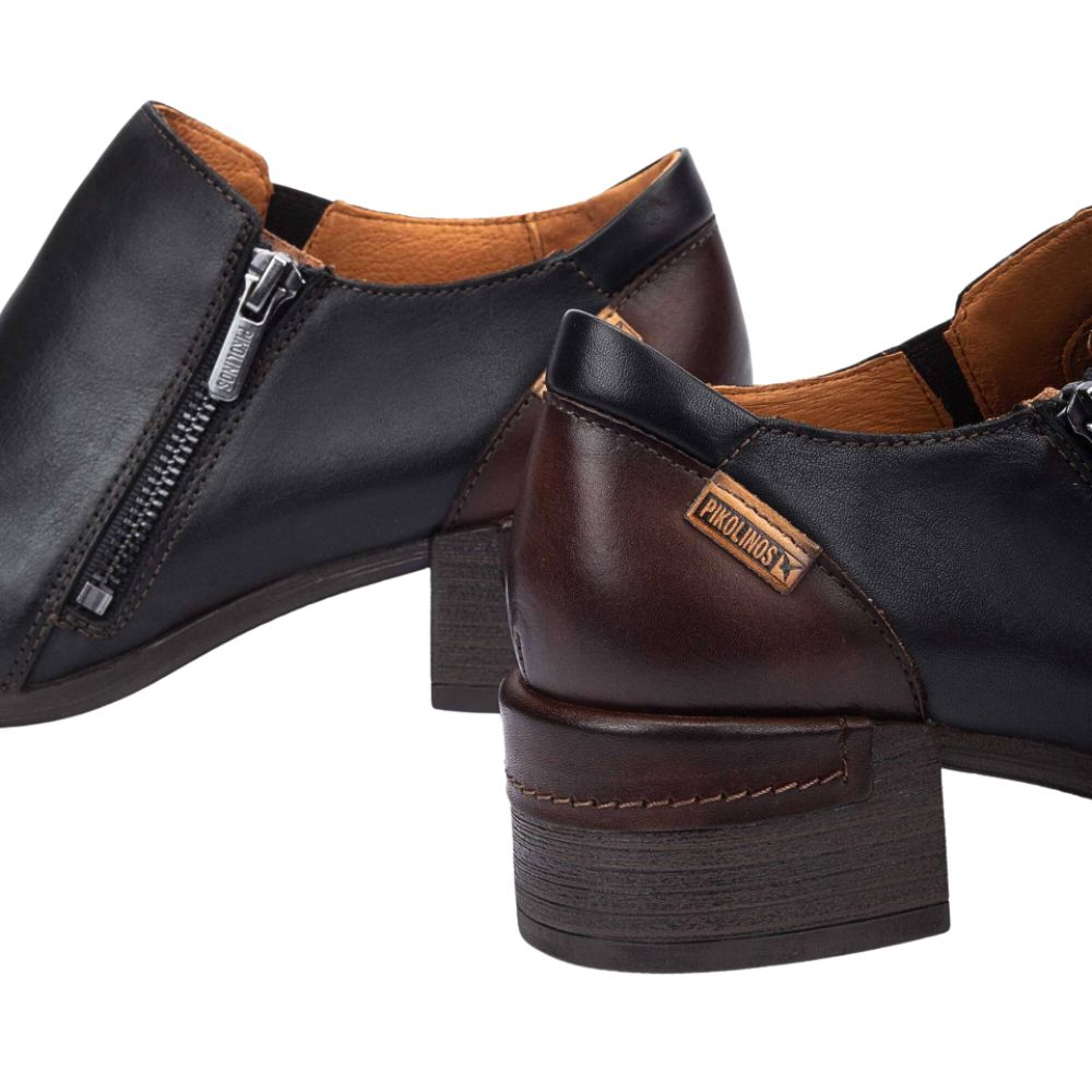 Pair of black and brown leather shoes with a visible brand logo on a white background