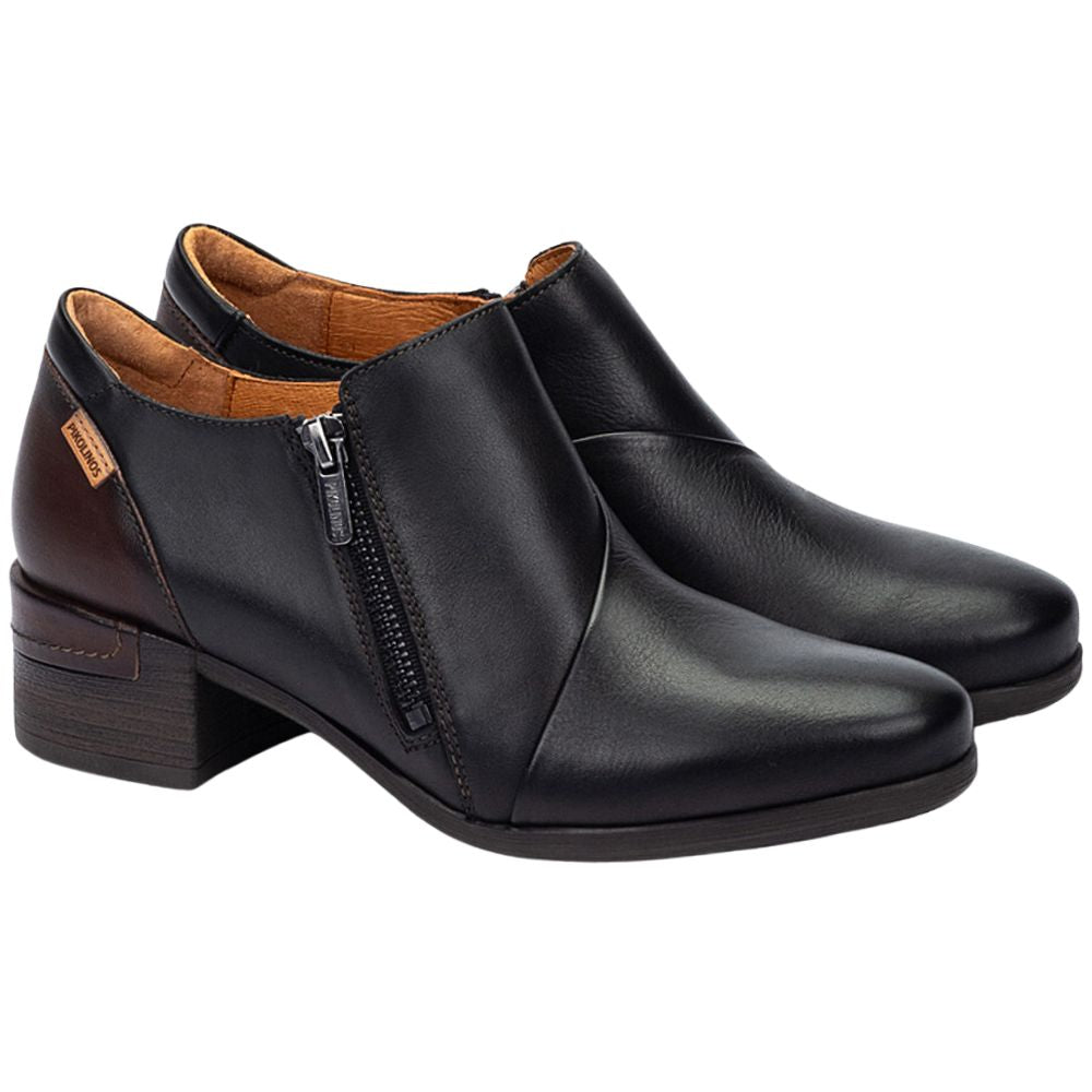 Pair of black leather shoes with a zipper on a white background