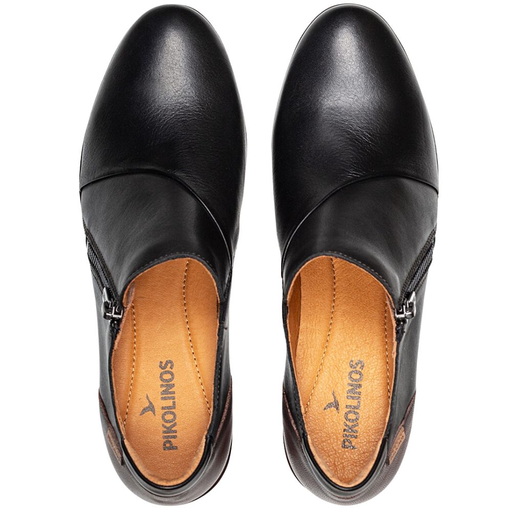 Pair of black leather shoes with 'Pikolinos' branding on a white background