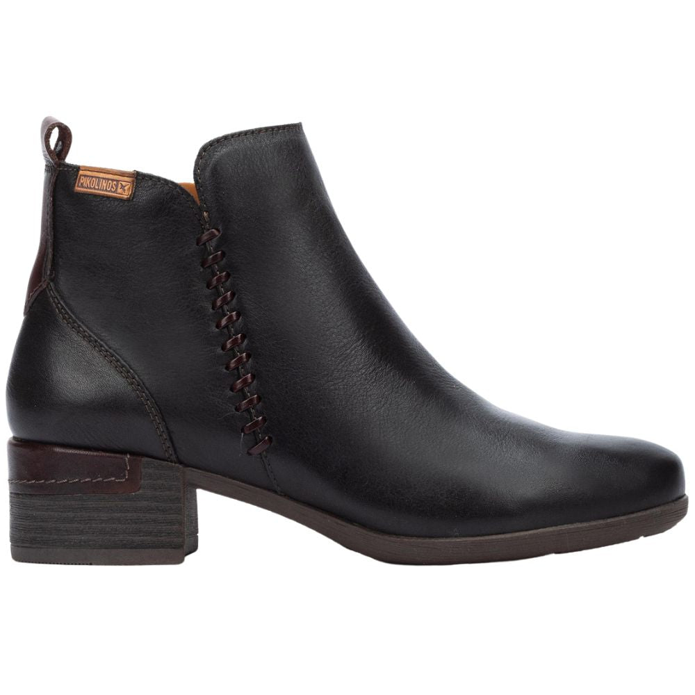 A black leather ankle boot with a low heel and inner zip entry, featuring detailed stitching.