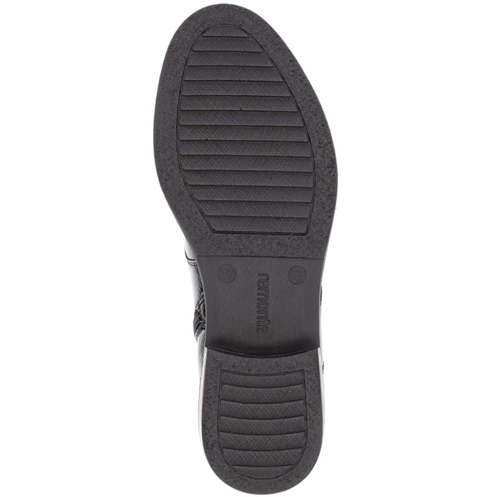 Close-up of a black shoe sole with tread pattern on a white background