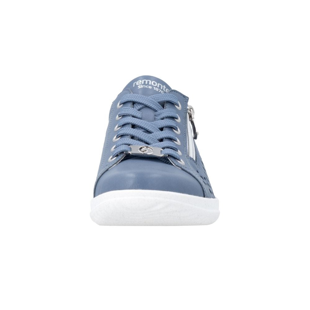 A single Remonte sneaker in a denim blue color, featuring matching blue laces, silver metal eyelets, a side zipper, and a white rubber sole, shown against a plain white background.