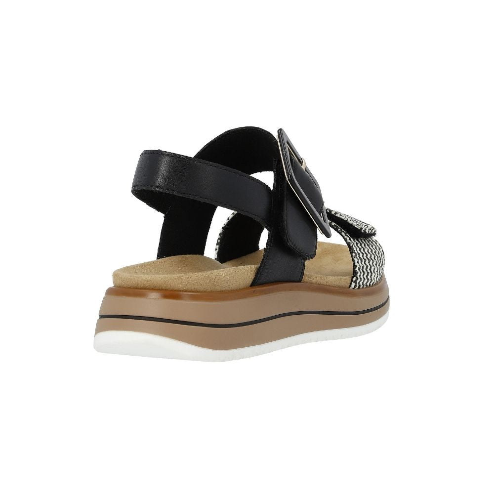 A single women's platform sandal shown from a rear three-quarter angle on a plain white background. The sandal features black leather straps, a textured white and black woven toe strap, a tan footbed, and a multi-layered platform sole with white, brown, and black sections.