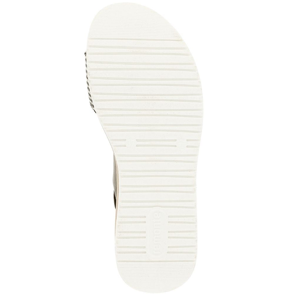 The white outsole of a single sandal, showing horizontal tread patterns and a small portion of the strap on the left side, isolated on a white background.