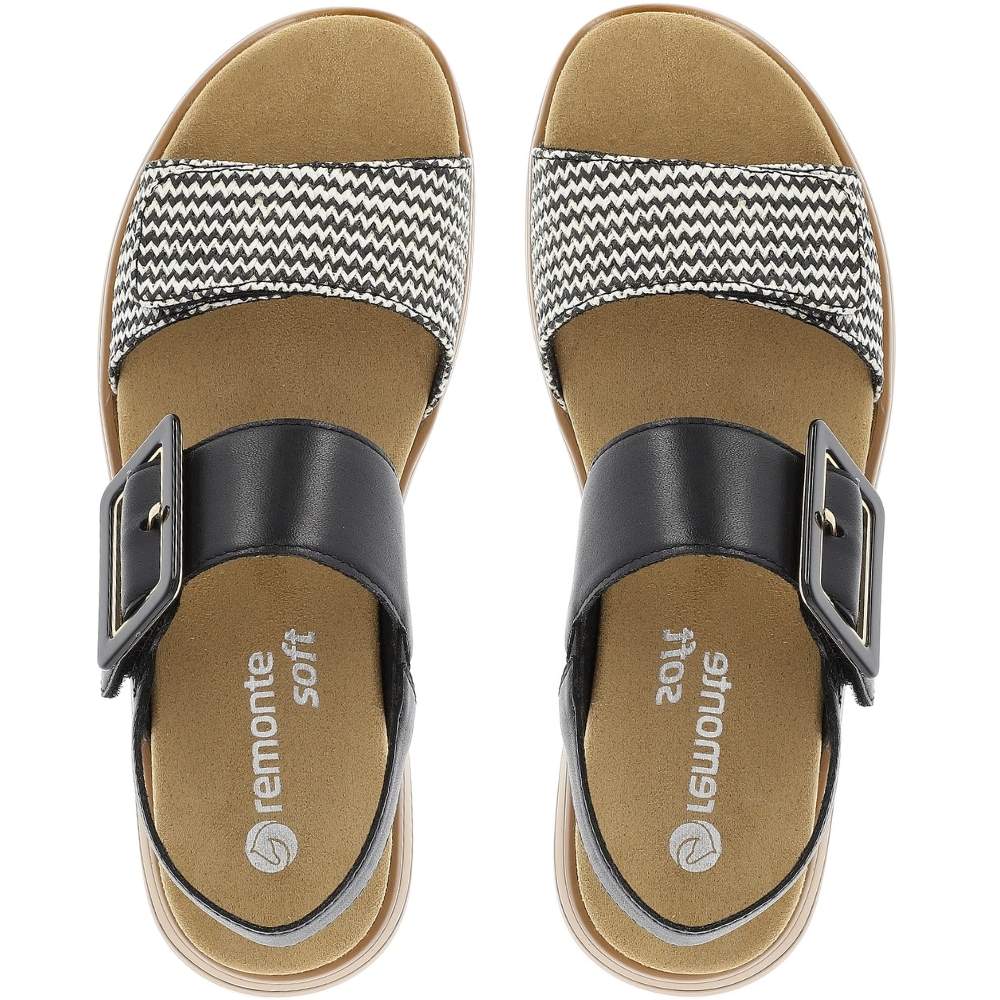 A pair of Remonte Soft women's slide sandals shown from a top-down view. The sandals feature a tan footbed, a wide black leather strap with a square buckle, and a black and white chevron-patterned woven strap.