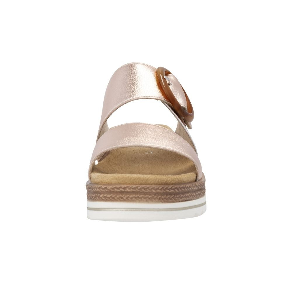 A single women's platform sandal shown from the front on a plain white background. The sandal features metallic rose gold leather straps, a circular statement buckle, and a jute-look and white platform sole.
