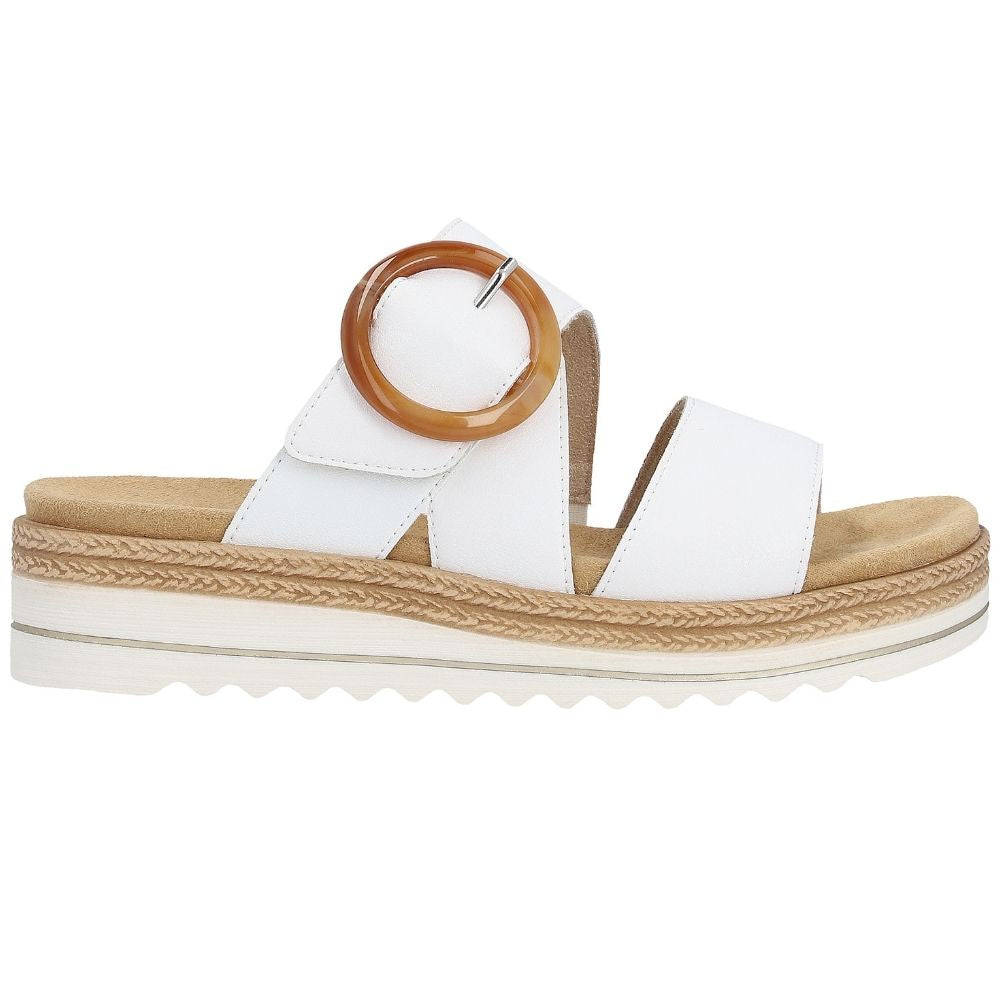 A single women's platform slide sandal in a white leather, featuring a statement amber buckle on the upper strap and a white platform sole with jute-look detailing.