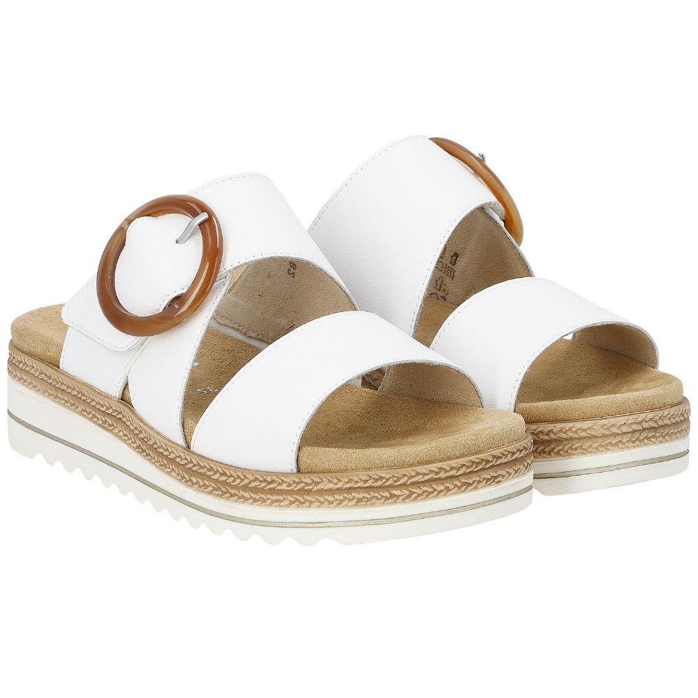 A pair of women's platform slide sandals in a white leather, featuring a statement amber buckle on the upper strap and a white platform sole with jute-look detailing.