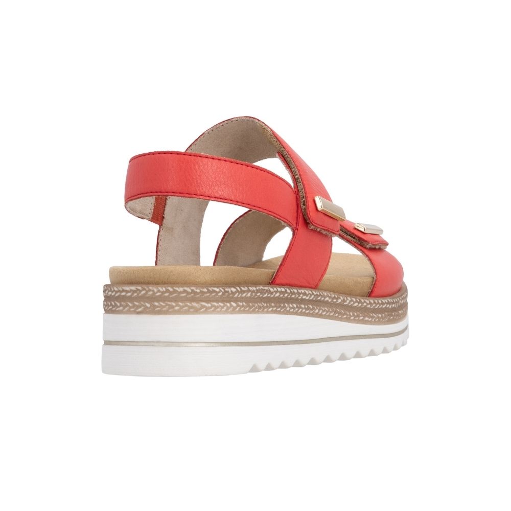 The back view of a red leather platform sandal with two adjustable straps, gold-tone metal accents, and a white wavy outsole with jute-look trim detail, shown from a side profile on a white background.