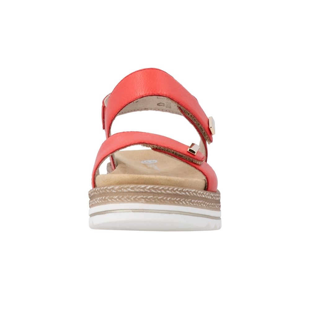 The front view of a red leather platform sandal with two adjustable straps, gold-tone metal accents, and a white wavy outsole with jute-look trim detail, on a white background.