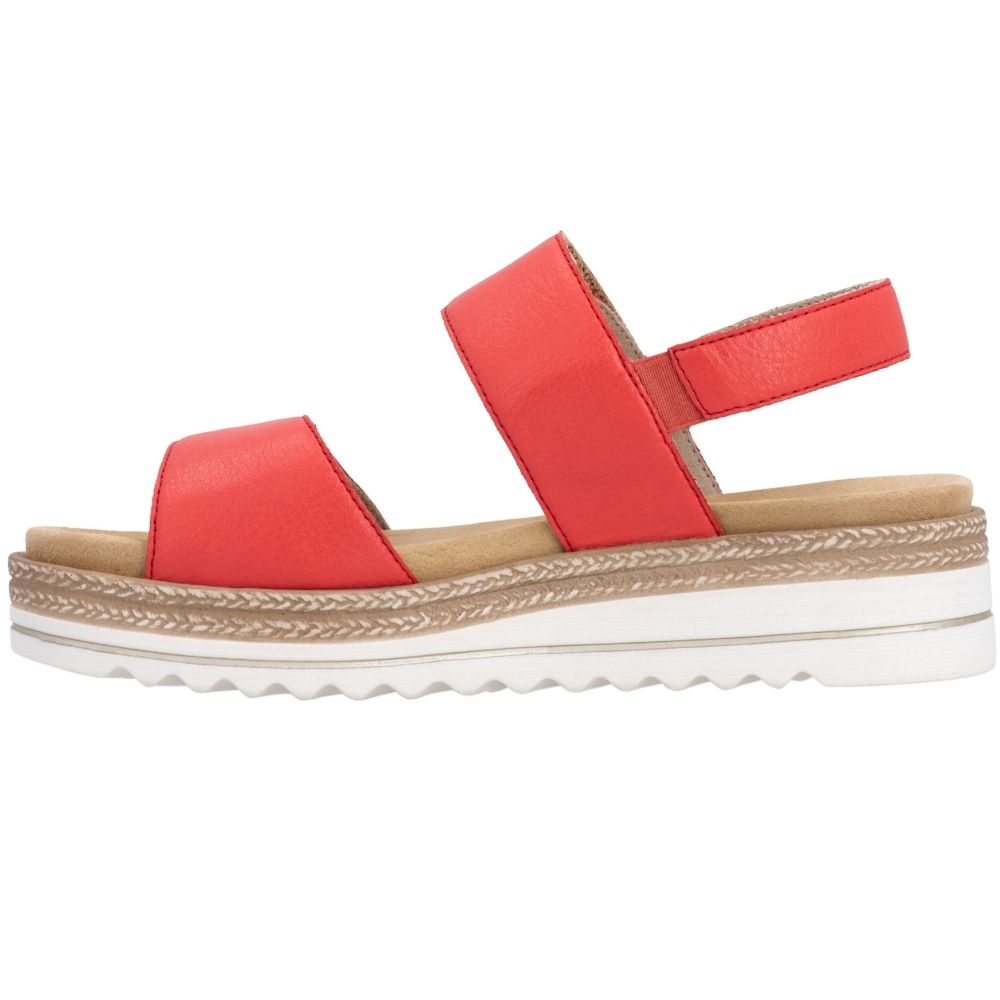The inside view of a red leather platform sandal with two adjustable straps and a white wavy outsole with jute-look trim detail, shown from a side profile on a white background.