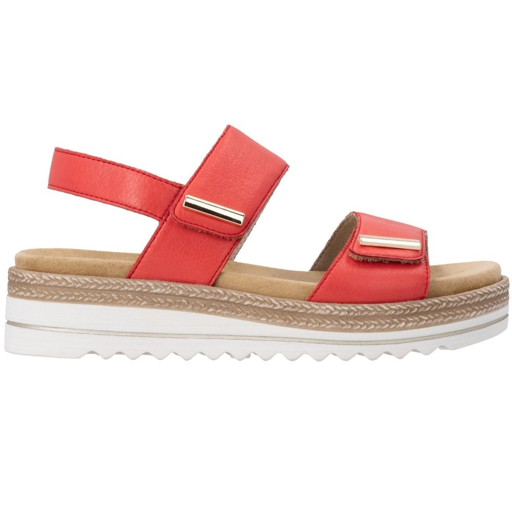 A red leather platform sandal with two adjustable straps, gold-tone metal accents, and a white wavy outsole with jute-look trim detail, shown from a side profile on a white background.