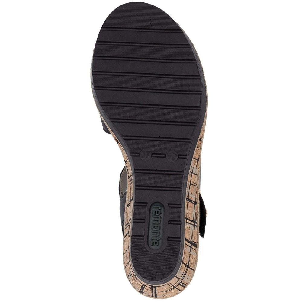 Top-down view of a sandal sole, showing a black textured tread with the brand name 'Remonte' embossed in the heel area, and a natural cork-look patterned side edge.