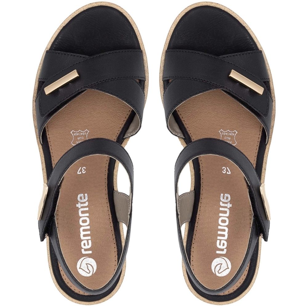 A pair of black leather wedge sandals with gold-tone metal accents and a tan insole, shown from a top-down view on a white background. The brand name 'remonte' is clearly visible on the insole.