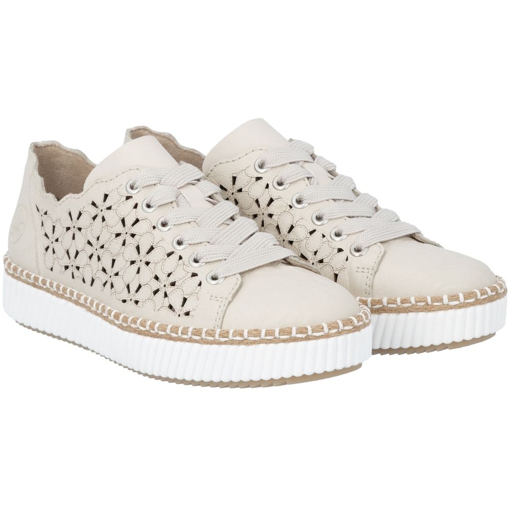A pair of low-top platform sneakers in a cream color, featuring decorative cutout patterns on the sides, matching cream laces, and thick white ridged soles.