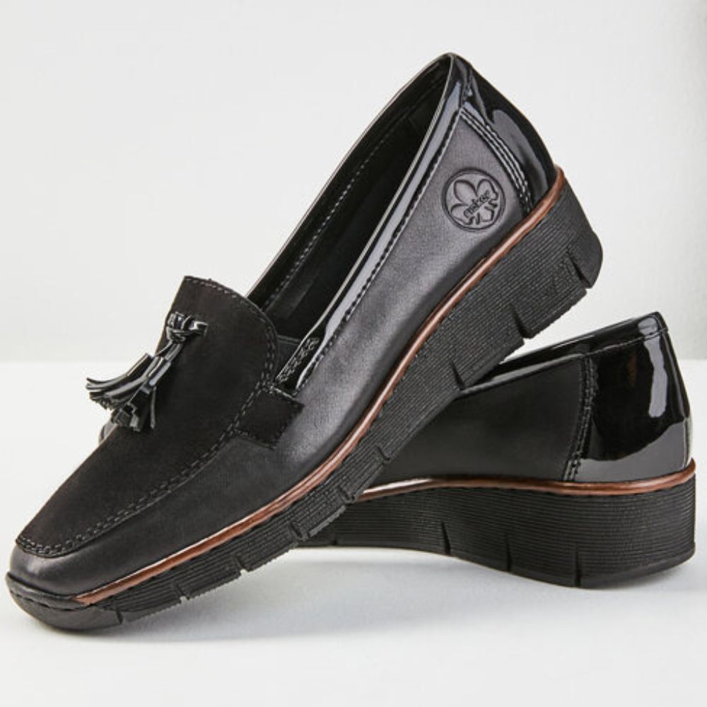 Pair of black loafers with a tassel on a white background